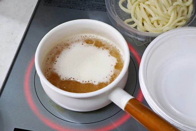 （１）加熱！　丸亀製麺で「冷たーい旨塩うどん」の並盛りを2杯持ち帰り、だしを鍋で沸騰。大盛りや得盛りで注文してもいいが、だしの量はそんなに多くない。並盛り2杯分あれば十分！