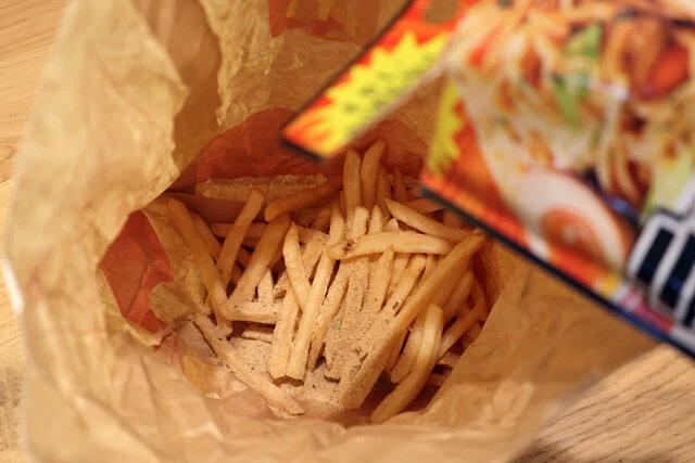 （１）入れる！　マックフライポテトを紙袋に移し、続いて「ラーメンの上だけ!!!」も入れる。量は目分量で大丈夫だが、ポテトがMサイズなら半袋程度を入れるのが目安だ