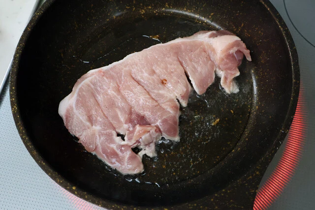 （２）焼く！　豚ロースの切り身に軽く塩こしょうを振り、2cmくらいの幅で切り込みを入れたら、油が残ったフライパンで両面を焼く。火力は中火?強火で、表面にカリッと焦げ目をつけよう