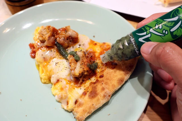 （５）カスタム！　最後に半熟玉子を戻し、割ってから食べよう。味変にはチューブ調味料のバジルやブラックペッパーがオススメ。ピザなので自由なトッピングでカスタムを楽しみましょう！