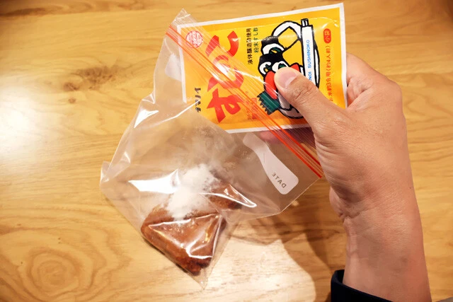 （１）入れる！　ファミチキをジップロックや紙袋などに移し、すしのこをたっぷりと入れる。チキンはもちろんLチキやななチキなどでも代用可能。お好みのコンビニチキンで試してみよう