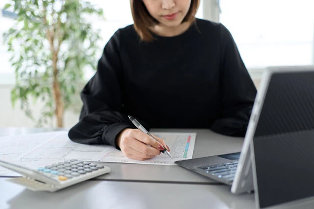 確定申告の書類を作成する女性のイメージ画像