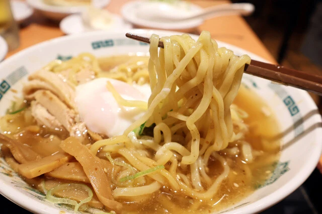 （３）食べる！　全体をよくかき混ぜ、底に入っているタレとスープを一体化させる。その後に温泉玉子を入れて食べよう。定番の中華そばとは完全に別モノ。もちもちの太麺が激ウマだ！
