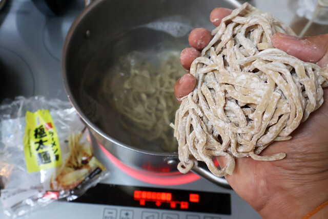 （２）ゆでる！　大きめの鍋にお湯を沸かし、豚ラーメン用極太麺をゆでたらざるに上げる。ちなみに今回は2玉使用しているが、もちろん通常サイズのペヤング＋麺1玉で作っても問題ない