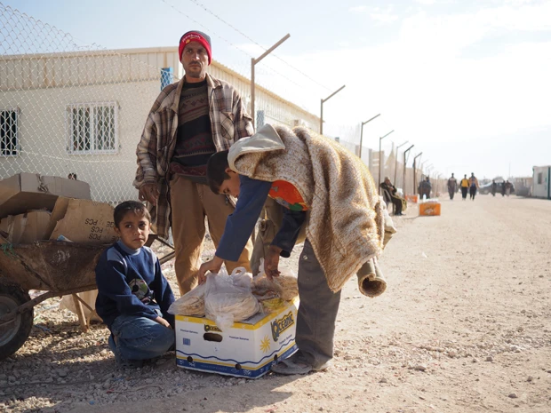 国連から配給されたパンをその場で売る親子。少しでも現金を得ようと、生活の糧を削る