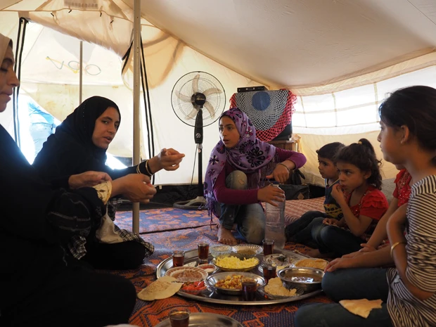 10人がひとつのテントに暮らすファティマさん一家。配給は最低限の食料だけだ