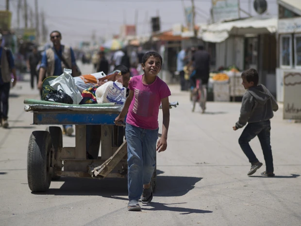 キャンプ内にある市場では、子供たちも労働力だ。炎天下、荷物運びの仕事をしてわずかばかりの現金を得る13歳の少年