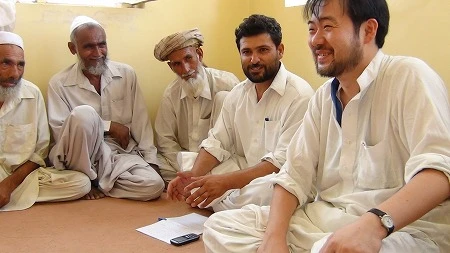 アフガニスタンの村落で。右端が長谷部さん。「外交は信頼関係の構築に尽きる」と断言する(写真提供:JVC)