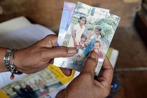  息子４人がＤＤＳに相次いで殺害されたと涙ながらに訴えるクラリタさん。息子らは窃盗やシンナー吸引などの軽犯罪の容疑をかけられていたという。手にした写真には生前の息子たちが写っていた