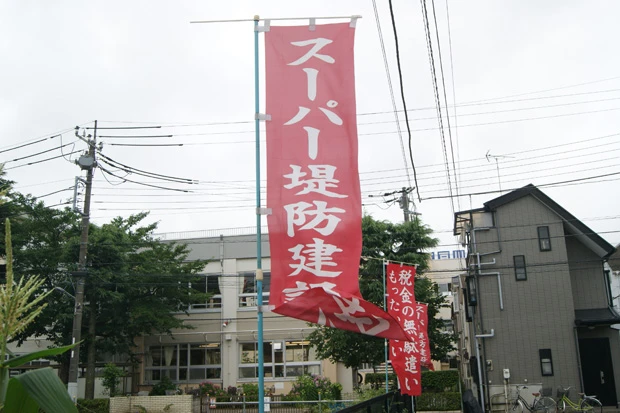 江戸川区篠崎地区で、立ち退きを拒み、計画反対の旗を掲げる家屋