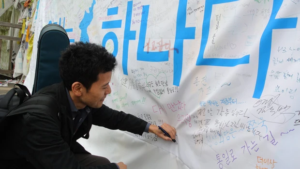 自由の橋に掲げられた巨大な横断幕に「統一」と寄せ書きをする筆者。