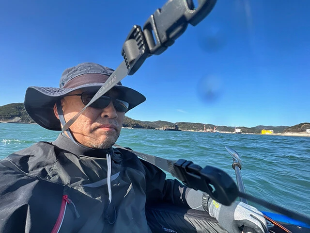 和歌山県・海自由良分遣隊基地沖、シーカヤックで海面に近い目線から「たいげい」撮影を試みる柿谷氏。左肩背後遠くに、潜水艦が視認できる