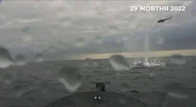 その艇搭載カメラが捕らえた映像。水平線にロシア海軍の軍艦が写っている。右上を飛ぶ艦載ヘリが自爆艇に対して銃撃を行っているが、当たらない（ウクライナ軍公開の映像より）