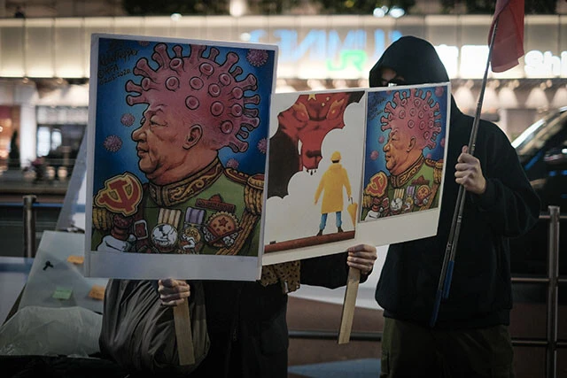 かなりグロテスクな「コロナ皇帝・習近平」の風刺画を掲げる新宿南口の抗議集会の参加者