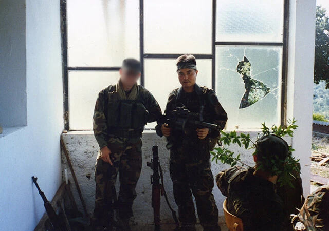 携帯ロケット砲を携える、傭兵、高部正樹氏。ロケットで隠れた左胸のポケットには自決用の五発の実弾が常に入っている。