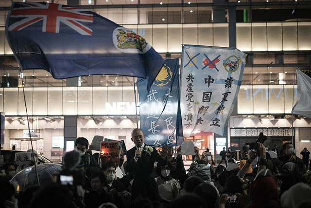 11月30日にJR新宿駅南口で行なわれた抗議集会。約1000人を集めたが、四川省独立を目指す謎の活動家（演説者の背後の2枚の旗）など、変な人にジャックされた面も