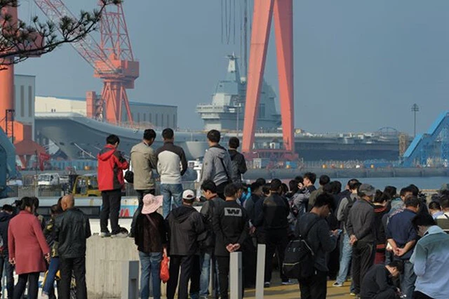 米空母艦隊に呼応して出撃した中国空母・山東・手前の中国人と比較するとその巨大さが分かる