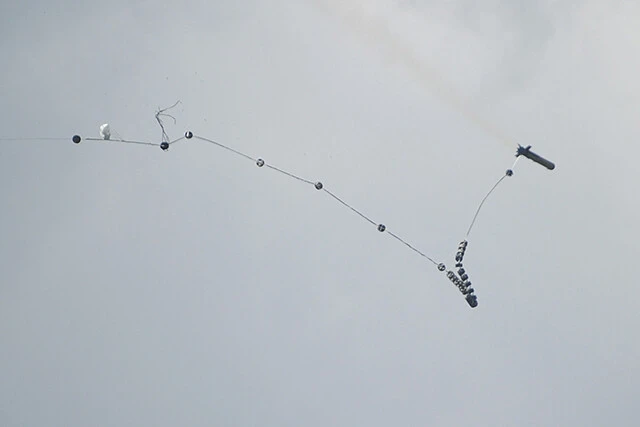 ロケットは爆薬を多数つけたロープを出しながら飛翔する（写真：柿谷哲也）