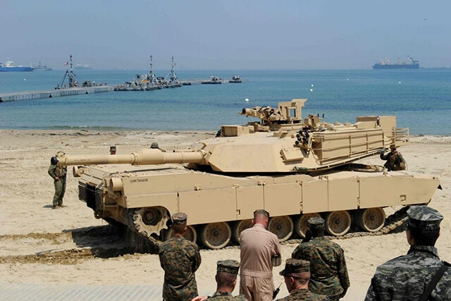 沖の事前集積船に搭載されていたM1A2戦車は、沖の浮桟橋経由でLCU2000型揚陸艇などに移し替えられて、写真右に見えるビーチ側の浮桟橋に到着。これを繰り返し米陸軍は戦力を蓄積する