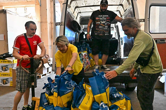 ヘルソン市中心部の支援物資倉庫で、袋分けにした食料などの物資をトラックに積んでいる。1回に約500袋が運ばれていく