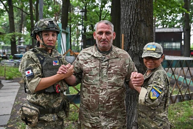 ジョージア軍団の兵士と本村さん(左)、本多さん(右)。本多さんはしばらく基地に滞在した後、日本へ帰国した