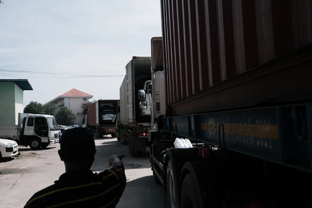 メソトの自動車が集まる拠点には日本車を載せたコンテナトラックが長い列を作っていた