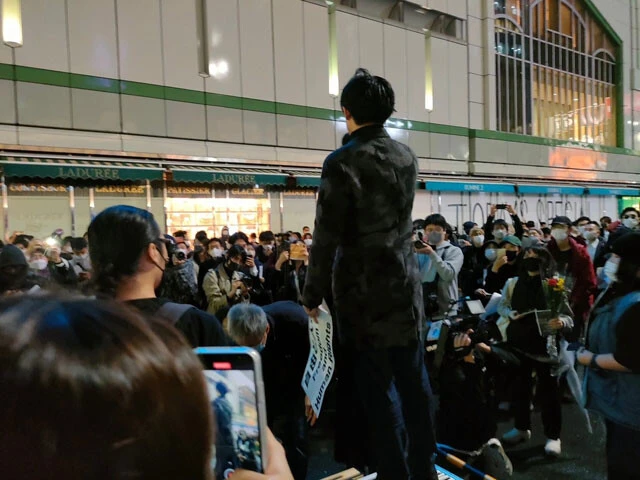 群衆を前に演説するデモの主催者。彼にカメラを向けるのは、デモの支持者だけとは限らない