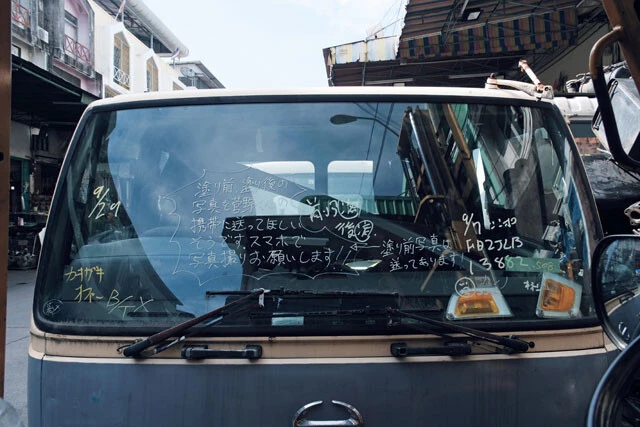 フロントガラスに〈塗り前、塗り後の写真を菅野君の携帯に送ってほしい〉と書かれた小型バス。塗装作業の途中だったのだろうか?