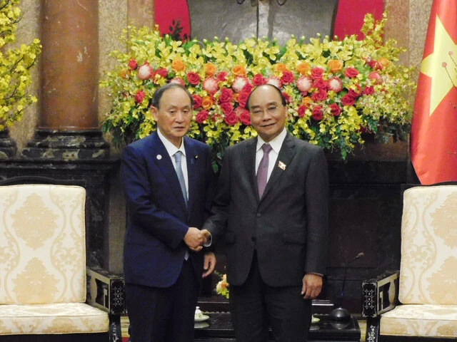 訪問先のハノイで当時のフック国家主席と握手を交わす菅元総理。この1週間あまりのち、フック氏は失脚した(写真:時事通信社)