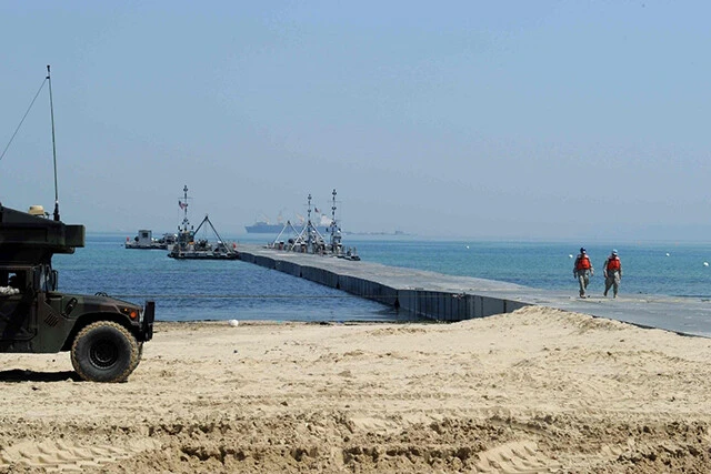 長い浮桟橋を作り、それを砂浜と繋ぎ、海岸に臨時桟橋を作る。