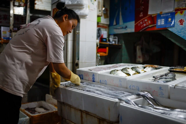 中国・北京の海鮮市場で魚を検査する業者