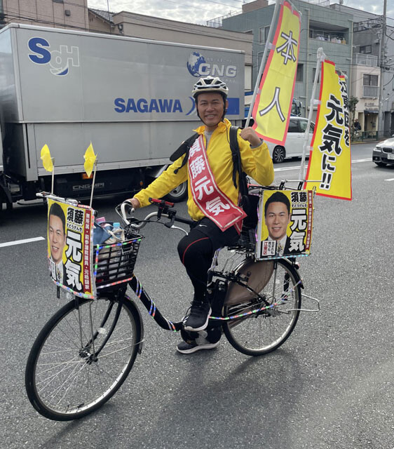 前回の補選と同じく電飾をつけた自転車で江東区の街を走りながら選挙活動する須藤氏。ビラを配るときは相手の目を見て、ちょっとトリッキーな動きで渡す