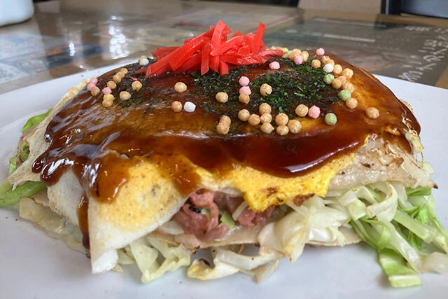 安芸高田市の新名物「あきたかた焼き」。広島焼きをベースに、そばと豚肉の代わりに餅と鶏肉を使用