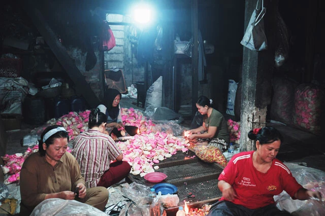 ムアラバル地区内の民家でスナック菓子を袋詰めする女性たち
