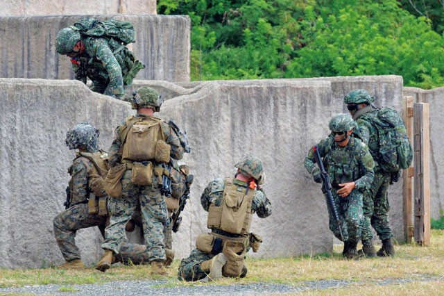 市街地戦闘（MOUT）訓練施設区域で塀を乗り越え、先陣を切るフィリピン兵