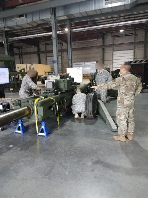 合衆国兵站大学には国中の陸曹や幹部、そして約26ヵ国からの留学生が集まる。榴弾砲を囲む生徒に指示をするサイトウ曹長