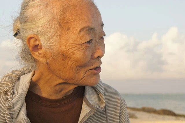 2023年3月、住民投票を求める声を無視して石垣駐屯地が開設。山里節子さんは、作品中で駐屯地の入り口で自衛隊員ひとりひとりの目を見ながら語りかける。「車両が通ります。道を開けてください」という自衛隊員の言葉に「道はいつでも開いている。平和な道をふさいだのはあなたたちじゃない!」と答えた