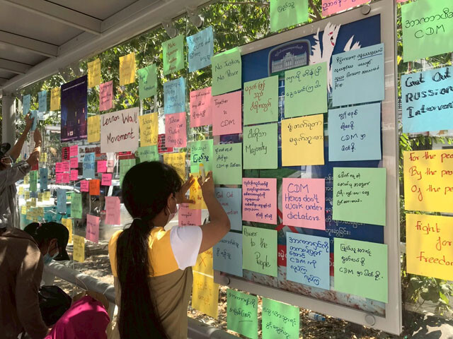 大学生たちが、バス停に「自由のために闘おう」など書かれたメッセージを貼っている。非暴力運動のひとつ（撮影：西方ちひろ）