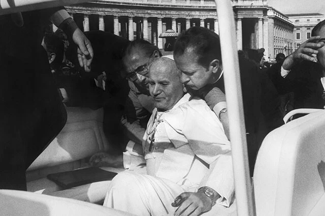 1981年5月13日、サン・ピエトロ広場で銃撃され、側近に運ばれるヨハネ・パウロ2世（中央）。実行犯はトルコ人だったが、計画したのはポーランド民主化への教皇の影響力を危惧した旧ソ連のKGBだったと後に判明。ヨハネ・パウロ2世は腹部と腕を撃たれて瀕死の重傷を負ったが、その後もポーランド民主化の支援を続けた