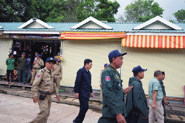 観光客が激減し、シャッターが閉まった店の前を通り過ぎる軍関係者