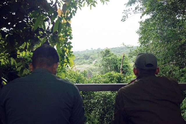 見通しの良い場所から双眼鏡を使ってタイ側の道路を監視するカンボジアの兵士