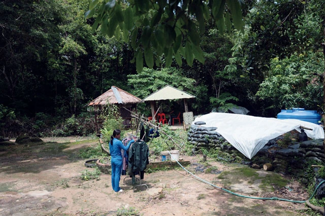 プレアビヒア寺院周辺、緊張の最前線に派遣されたカンボジア軍兵士に家族も同行。洗濯物を干す女性の前には塹壕(ざんごう)が見える