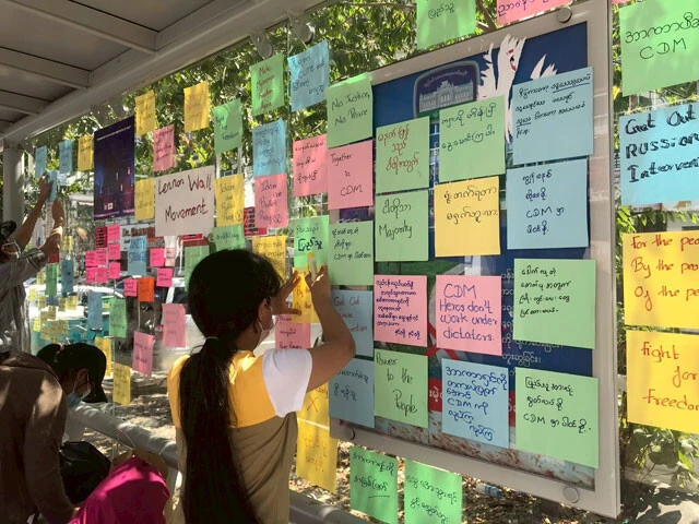 大学生たちが、バス停に「自由のために闘おう」など書かれたメッセージを貼っている。非暴力運動のひとつ（撮影：西方ちひろ）