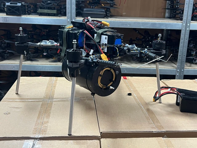 機体下部に筒を装着したFPVドローン。筒の内部には50km分の光ファイバーが巻き取られており、飛行中も有線で映像と操縦信号を伝送する