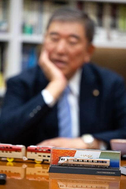 サンライズ出雲のプラレールや、ハイブリッド車両のHC85系（手前）の模型を眺めながら鉄道トークをする石破さん