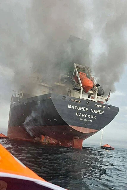 中東ホルムズ海峡を航行中に襲撃され、煙が上がるタイ船籍の貨物船（3月11日、タイ海軍提供）