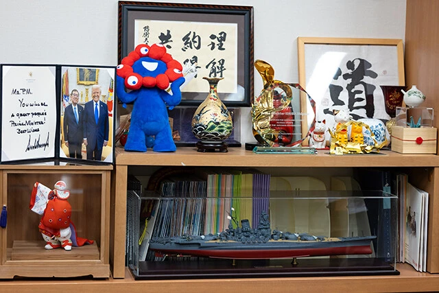 石破さんの国会事務所内の様子。ミャクミャクの人形、350分の1スケールの戦艦大和のプラモデルなどのグッズが所狭しと置いてある