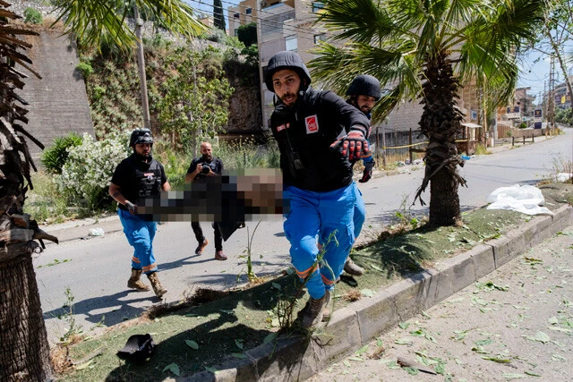 バイクを運転していたところ、イスラエル軍のドローンに爆撃された男性を救助する隊員たち。上空では戦闘機の音が響いていた