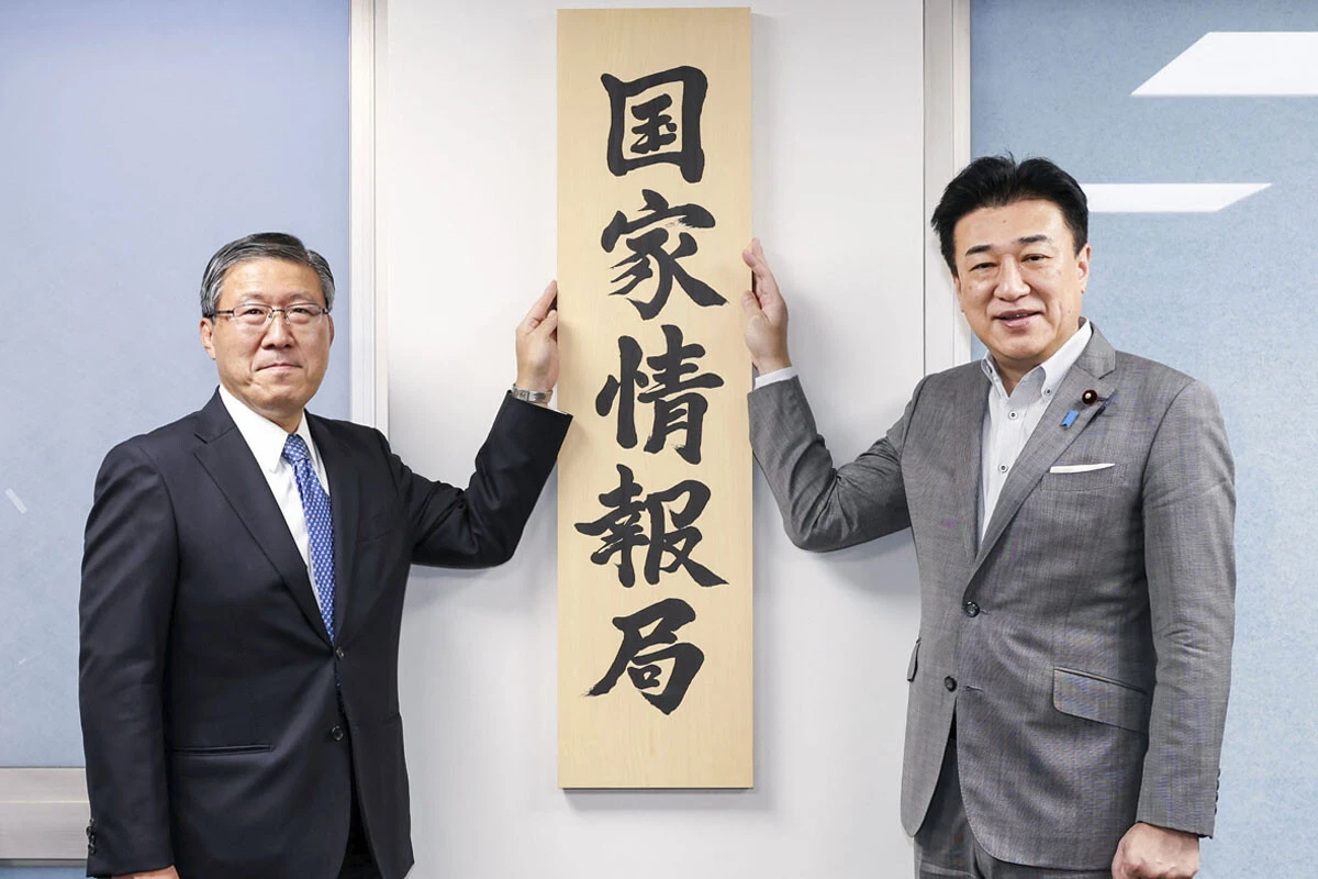 7月31日、「国家情報局」の看板を掲げる原和也国家情報局長（左）と木原稔官房長官（右）。同日、首相や関係閣僚が参加する国家情報会議の初会合も開かれた