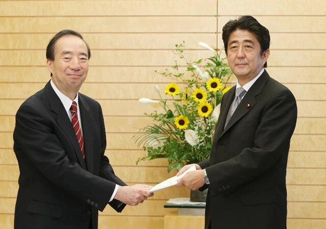2013年8月に「社会保障制度改革国民会議」の清家 篤会長（左）から報告書を受け取る安倍晋三首相（当時）。この報告書では2025年までの社会保障制度のロードマップが描かれていた